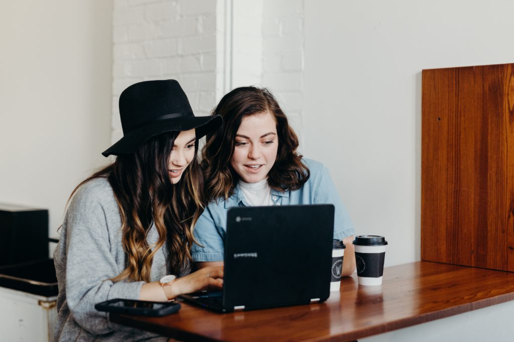 Two girls looking at a laptop screen